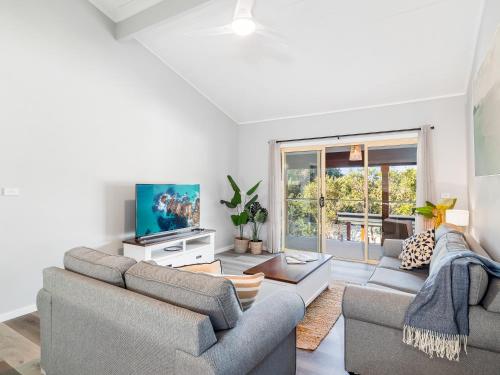 a living room with a couch and a tv at Myley's Flat in Forster