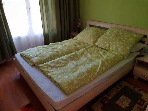 a bedroom with a bed with yellow sheets and a window at Ferienhaus Alexandra in Balatonberény