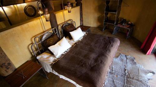 a bedroom with a bed with a blanket on it at Ongula Village Homestead Lodge in Omupumba