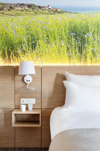 a bedroom with a bed and a view of a field at Best Western Le Beffroi in Loos