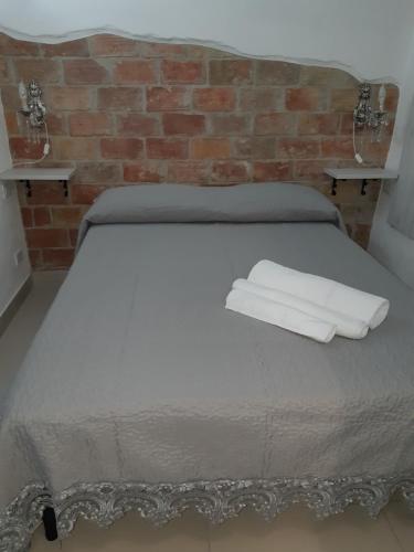 a bed with two white towels on top of it at B&B Lutri in Trebisacce