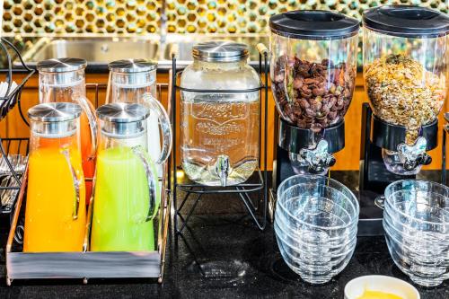 a counter with several jars of orange juice and drinks at The Grand Sala Thai in Bangkok