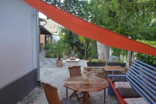 a patio with a bench and a table and chairs at Das Nest in Eisenstadt