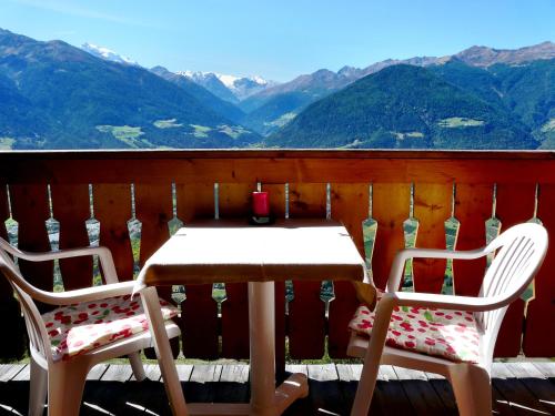 a table and two chairs on a balcony with mountains at B & B Apartments Ortlerblick in Sluderno