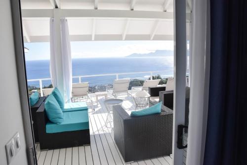 a hotel room with a balcony overlooking the ocean at Ninamu Pearl Guest House in Punaauia