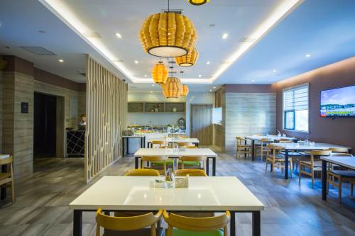 西安西安北二环文景路亚朵酒店（原凤城一路店）的餐厅设有白色的桌子和黄色的椅子