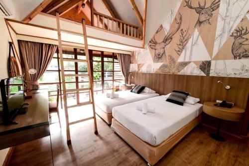 1 dormitorio con 2 camas y un mural en la pared en Issara Boutique Winery Hotel, en Muak Lek