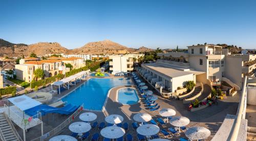 a resort with a swimming pool and umbrellas at Delfinia Resort - All Inclusive in Kolymbia