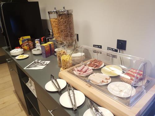 a counter with plates of food on a table at Hotel Enight in Gradignan