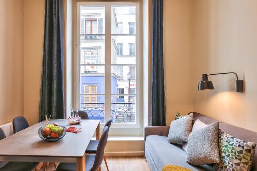 - un salon avec une table, un canapé et une fenêtre dans l'établissement 94 - Urban French Kiss Montorgueil, à Paris