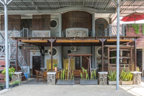 a building with a balcony with tables and chairs at RedDoorz Syariah near RRI Malang in Malang