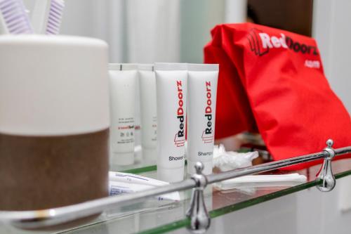 a shelf with three tubes of toothbrushes and a bag at RedDoorz near Universitas Widyagama Malang in Malang