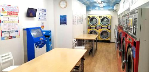 a laundry room with washing machines and a washer and dryer at Astil Hotel Shinosaka Precious in Osaka