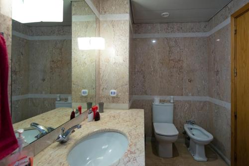a bathroom with a sink and a toilet at Funchal Bay View Holiday Rental in Funchal