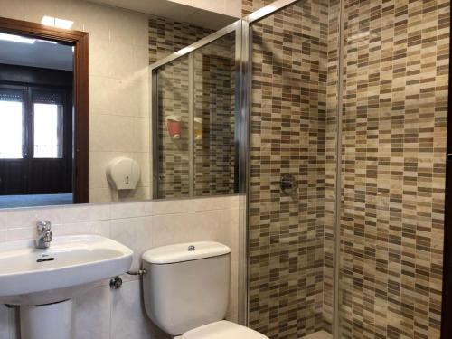 a bathroom with a toilet and a sink and a shower at Bearan Bar & Rooms in Pamplona