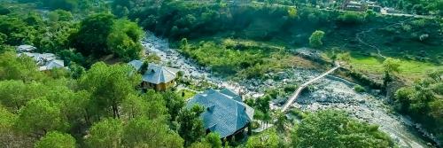 an aerial view of a house next to a river at Prakriti Aalay - Riverside Mountain View Boutique Eco Resort in Dharamshala