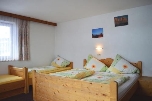 a bedroom with a wooden bed and a window at Pension Leitenhof in Niederau