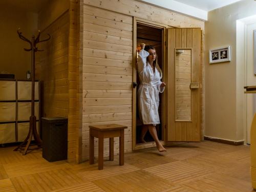 a woman in a white dress standing in a door at La Ferme Du Lac in Thyez