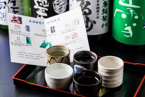 a tray with four cups on a table with drinks at Izu Mitohama Shotokan in Numazu