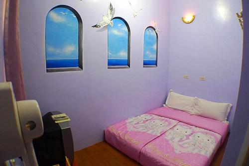 a bedroom with a bed and three windows at Hai Zhi Dao Min Su in Magong