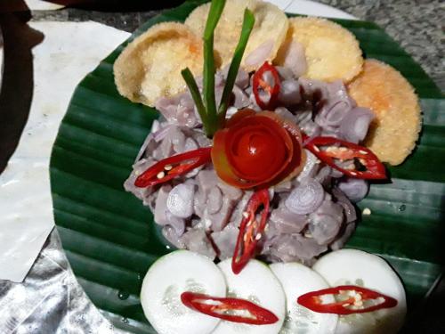 a green plate of food on a green leaf at Sunset Cottages in Hitokalak