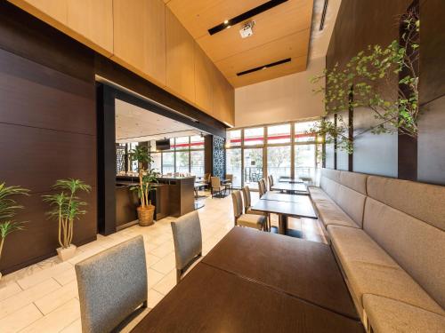 a dining room with tables and chairs and plants at Hotel JAL City Haneda Tokyo in Tokyo