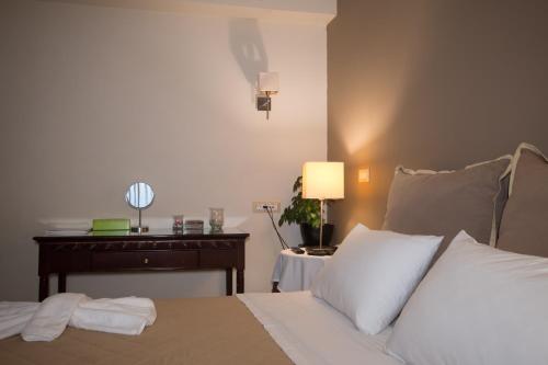 a bedroom with a bed and a table with a lamp at Dali in Zakynthos