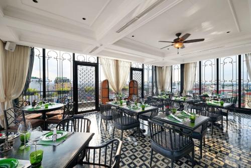 a dining room with tables and chairs and windows at La Siesta Premium Hang Be in Hanoi
