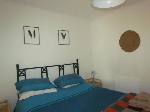 a bedroom with a blue bed and two pictures on the wall at Pumula Guest Farm in Fouriesburg