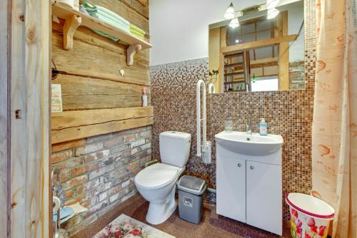 a bathroom with a toilet and a sink at Atomiņi in Aucugals