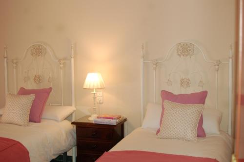 a bedroom with two beds and a table with a lamp at LA ATALAYA GREAT LUXURY ATTIC in Antequera