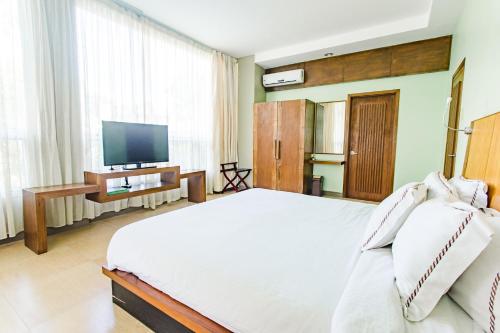 a bedroom with a large bed and a television at The Park - Silang in Silang