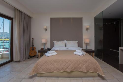 a bedroom with a large bed with towels on it at Dali in Zakynthos