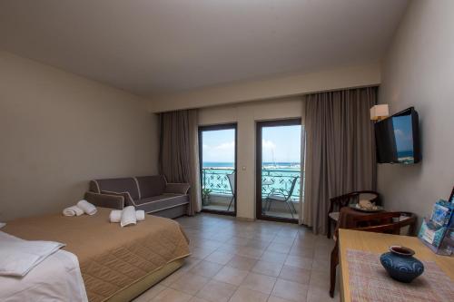 a hotel room with a bed and a couch and a television at Dali in Zakynthos