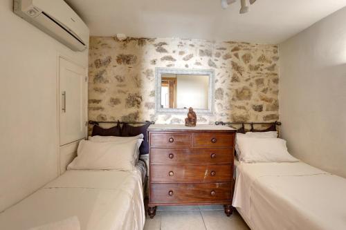a bedroom with two beds and a dresser and a mirror at Heart Of Valbonne in Valbonne