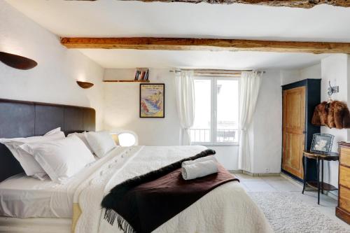 a bedroom with a large bed and a window at Heart Of Valbonne in Valbonne