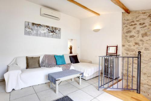 a living room with a white couch and a table at Heart Of Valbonne in Valbonne