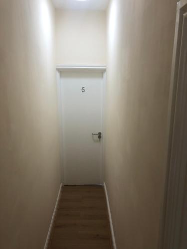 a hallway with a white door and a wooden floor at Smeaton serviced Accommodation in Liverpool