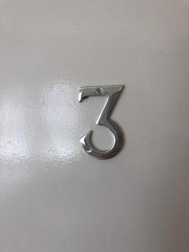 a metal number seven on a white wall at Smeaton serviced Accommodation in Liverpool