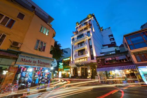a busy city street at night with buildings at La Siesta Premium Hang Be in Hanoi