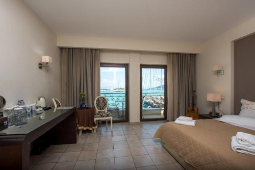 ein Hotelzimmer mit einem Bett, einem Schreibtisch und einem Balkon in der Unterkunft Dali in Zakynthos