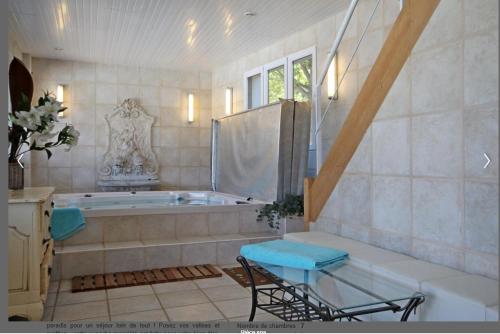 a large bathroom with a tub and a chair at Grande villa d'exception en Normandie tennis, piscine, jacuzzi, salle de fitness in Muids