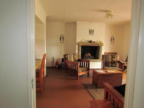 a living room with a fireplace and wooden furniture at Pumula Guest Farm in Fouriesburg