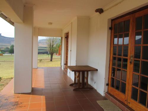 a porch with a wooden bench next to a door at Pumula Guest Farm in Fouriesburg