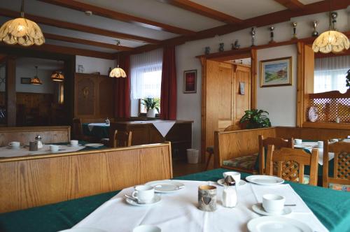 a dining room with a table with dishes on it at Pension Leitenhof in Niederau