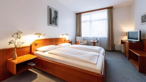 A bed or beds in a room at Hotel Am Stadtpark