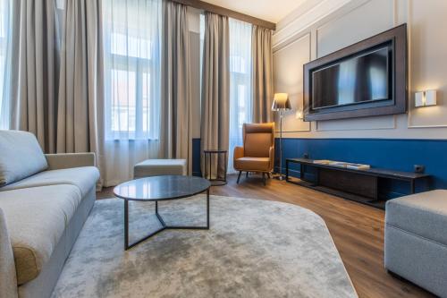 a living room with a couch and a tv at Radisson Blu Hotel Prague in Prague