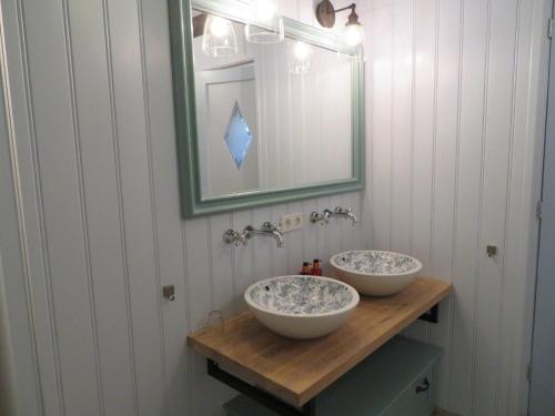 uma casa de banho com 2 lavatórios num balcão de madeira com um espelho em B&B Singelstate em Gorredijk
