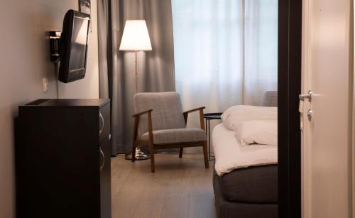 a room with a tv and a chair and a table at Best Western Tingvold Park Hotel in Steinkjer