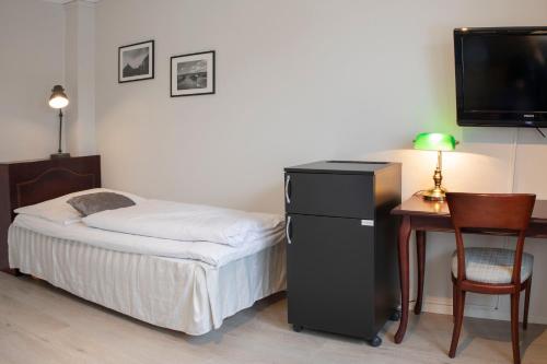 a bedroom with a bed and a desk with a television at Best Western Tingvold Park Hotel in Steinkjer